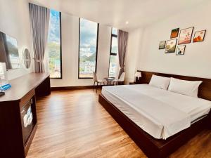 a bedroom with a large bed and some windows at Cát Bà Swiss Hotel in Cat Ba +185 photos