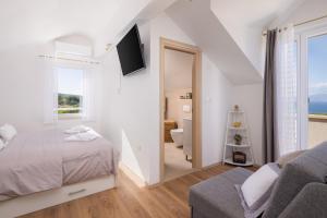 Ein weißes Zimmer mit einem Bett und einem Bad. in der Unterkunft Villa Fani in Supetar + 43 Fotos