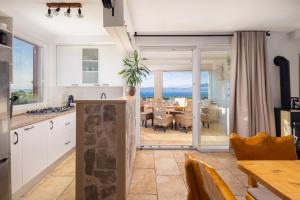 eine Küche und ein Esszimmer mit Blick auf das Meer in der Unterkunft Villa Fani in Supetar