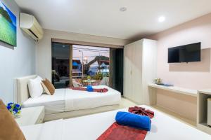 ein Wohnzimmer mit zwei Betten und einem Fernseher in der Unterkunft Mookanda Residence in Ao Nang Beach