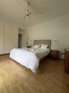 ein Schlafzimmer mit einem großen weißen Bett und Holzböden in der Unterkunft Ellados in Strovolos