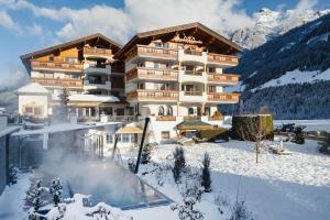 a hotel in the snow with a swimming pool at Hotel Stubaierhof in Neustift im Stubaital