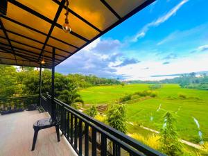 a balcony with a view of a golf course at Meadow View Villa in Dickwella