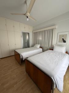 ein Schlafzimmer mit zwei Betten und einem Deckenventilator in der Unterkunft Ellados in Strovolos