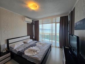 a bedroom with a bed and a large window at Family Complex Gallery - Sunny Beach in Sunny Beach +42 photos