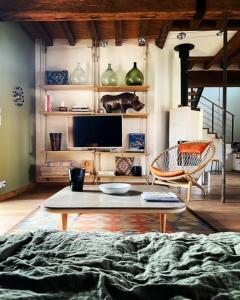 ein Wohnzimmer mit Fernseher und Couchtisch in der Unterkunft Maison Manoé in Sens sur Seille