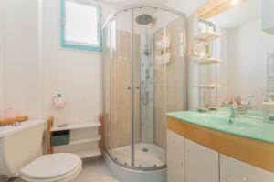 a bathroom with a shower and a toilet and a sink at Les Mille Et Une Voiles Appart T2 in Port Leucate +18 photos