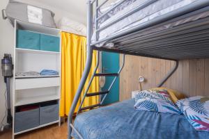 a bedroom with a bunk bed with a blue comforter at Les Mille Et Une Voiles Appart T2 in Port Leucate