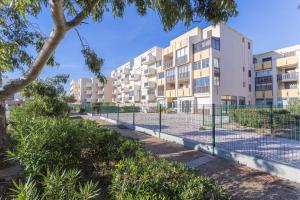 an apartment building with a fence and trees at Les Mille Et Une Voiles Appart T2 in Port Leucate