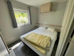 a small bedroom with a bed and a window at Camping 3 étoiles - Piscine - eehhec in Landry