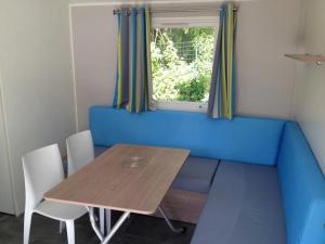 a dining table and chairs in a tiny house at Camping 3 étoiles - Piscine - eehhec in Landry