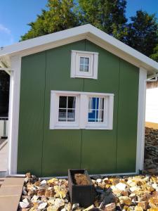a green building with a window and a pile of rocks at Ferienhaus Mit Grill In Bad Marienberg in Bad Marienberg +5 photos