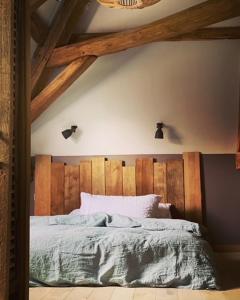 ein Schlafzimmer mit einem Bett mit hölzernem Kopfteil in der Unterkunft Maison Manoé in Sens sur Seille + 21 Fotos