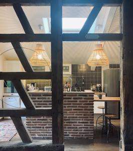 eine Küche mit zwei Kronleuchtern und einer Backsteinwand in der Unterkunft Maison Manoé in Sens sur Seille
