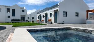a courtyard with a swimming pool in front of a house at Black Eagle's Rest #Unit 1-8 in Langebaan