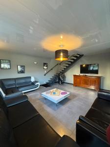 un salon avec un canapé et un escalier dans l'établissement Coeur d'Argonne, à Dombasle-en-Argonne