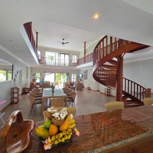 sala de estar con escalera y mesa con fruta en Surf Tropical Villa Seascape, en Isla de Cerf