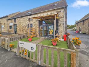 a small brick building with a porch with a fence at L'horizon du bonheur in Litteau