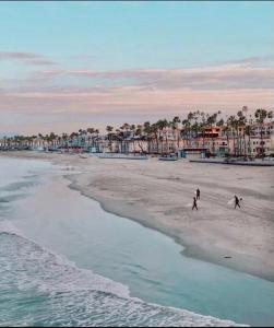 twee mensen lopen op het strand bij het water bij 5N-31 Beach View BBQ & Jacuzzi in Oceanside