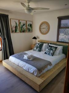 ein Schlafzimmer mit einem großen Bett mit einer Uhr an der Wand in der Unterkunft Out to Sea in Wilderness