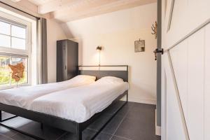 a bedroom with a bed and a window at Villa Linde | 4 personen - Vakantiepark De Kremmer in Gasselte