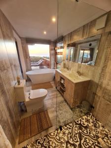 ein Badezimmer mit Badewanne, Toilette und Waschbecken in der Unterkunft Out to Sea in Wilderness