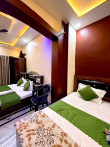 a hotel room with two beds and a table at Guru Amrit Residency & Guru Kripa Guest house in Ayodhya