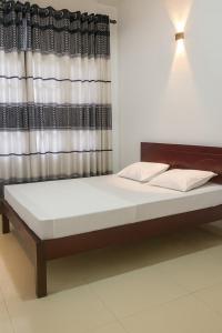 a large bed in a room with a window at Comfy Stay in Badulla