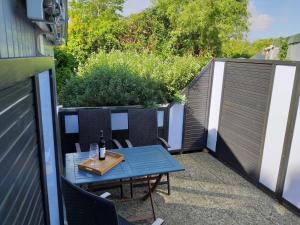 a patio with a table with a bottle of wine at Ferienhaus Ostwaldt - zwischen Stralsund und Greifswald in Kirchdorf