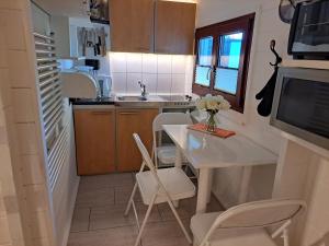 a small kitchen with a white table and chairs at Ferienhaus Ostwaldt - zwischen Stralsund und Greifswald in Kirchdorf +5 photos