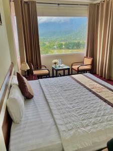 a bedroom with a large bed with a large window at Khoa Thanh Hotel in Mai Chau