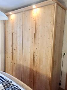 ein großer Holzschrank in einem Zimmer mit einem Bett in der Unterkunft Ferienwohnung in Frauenberg mit Garten in Haidmühle