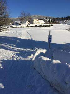 eine schneebedeckte Straße mit einem Schild in der Mitte in der Unterkunft Ferienwohnung in Frauenberg mit Garten in Haidmühle + 13 Fotos
