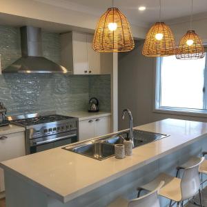 a kitchen with a sink and a stove at Seafoam, Cowes, New Home, Fast NBN WIFI in Cowes +19 photos