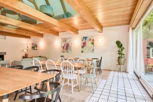 a dining room with wooden ceilings and tables and chairs at Das Wewelsflether Bäckerhaus - 250qm für 12 Gäste in Wewelsfleth +20 photos