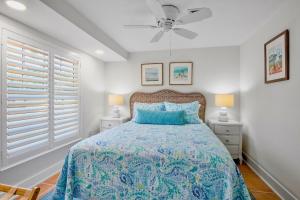 a bedroom with a bed and a ceiling fan at Lavender Lagoon in Anna Maria +31 photos