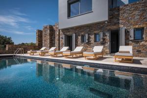 ein Swimmingpool mit Liegestühlen neben einem Gebäude in der Unterkunft Ferienhaus mit Privatpool für 8 Personen ca 180 m in Agios Nikolaos, Kreta Ost-Kreta in Agios Nikolaos + 25 Fotos