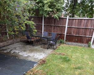 a patio with a table and chairs in a backyard at Flamingo Short Lets Greenleys in Wolverton