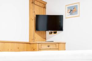 ein Flachbildfernseher auf einem Holzschrank in der Unterkunft EL CIASEL in Canazei