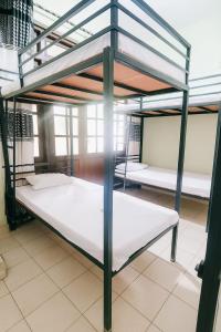 a room with three bunk beds with white sheets at Comfy Stay in Badulla