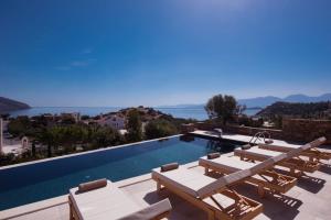 einen Pool mit Liegestühlen und Blick auf das Wasser in der Unterkunft Ferienhaus mit Privatpool für 8 Personen ca 180 m in Agios Nikolaos, Kreta Ost-Kreta in Agios Nikolaos