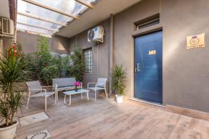 eine Terrasse mit einer blauen Tür sowie Stühlen und Pflanzen in der Unterkunft Sp Luxury Room - Catania in Cannizzaro