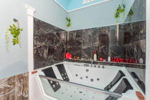 eine Badewanne im Bad mit schwarzen Fliesen in der Unterkunft Sp Luxury Room - Catania in Cannizzaro + 35 Fotos