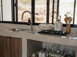 a kitchen counter with a sink and a stove at Bergendam Eco Lodge in Venterstad +105 photos