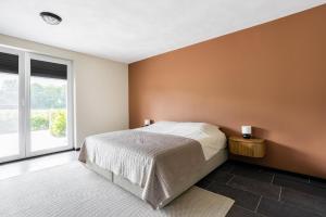 a bedroom with a bed and a large window at Villa Crème de la Kremmer met Hottub & Sauna | 8 personen in Gasselte