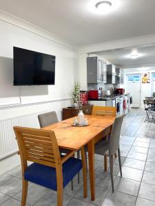 ein Esszimmer mit einem Holztisch und Stühlen in der Unterkunft 12 Penn Gardens- Apart 2 in Friern Barnet