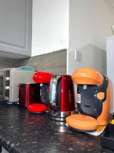 eine Küchentheke mit verschiedenen Geräten auf einer Arbeitsplatte in der Unterkunft 12 Penn Gardens- Apart 2 in Friern Barnet