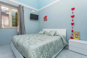 ein Schlafzimmer mit einem Bett und einem Fernseher an der Wand in der Unterkunft Sp Luxury Room - Catania in Cannizzaro