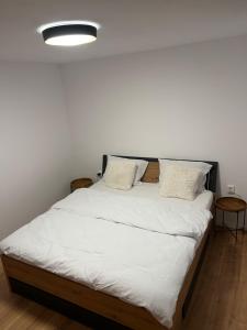 a bed with white sheets and pillows in a room at Arbor in Vadul lui Carol II