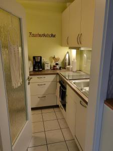 eine kleine Küche mit weißen Schränken und einer Spüle in der Unterkunft Ferienwohnung Am Heimathof in Dorsten + 3 Fotos